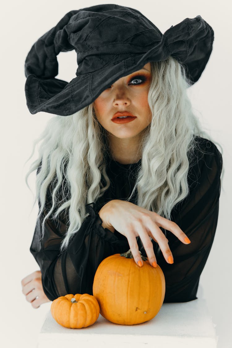 Woman In Black Witch Costume With Two Pumpkins