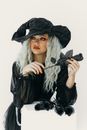 身着黑色服装的时尚女巫手持黑玫瑰，是完美的万圣节主题内容
