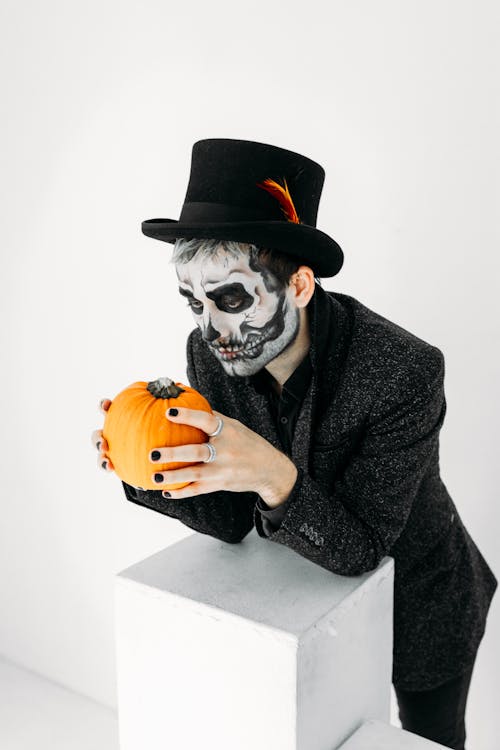 Free Man With A Scary Face Paint Holding A Pumpkin Stock Photo