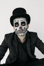 一个戴着大礼帽、化着头骨妆容、穿着怪异的男人肖像，非常适合万圣节主题
