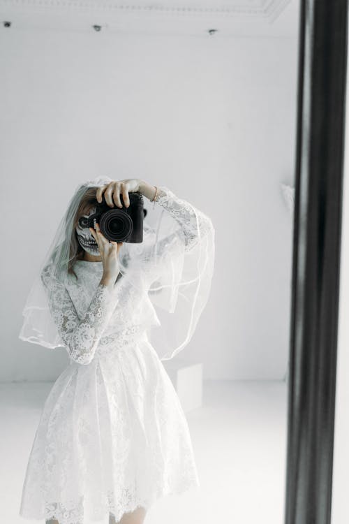 Wanita Dalam Gaun Pengantin Renda Bunga Putih Memegang Kamera Dslr Hitam