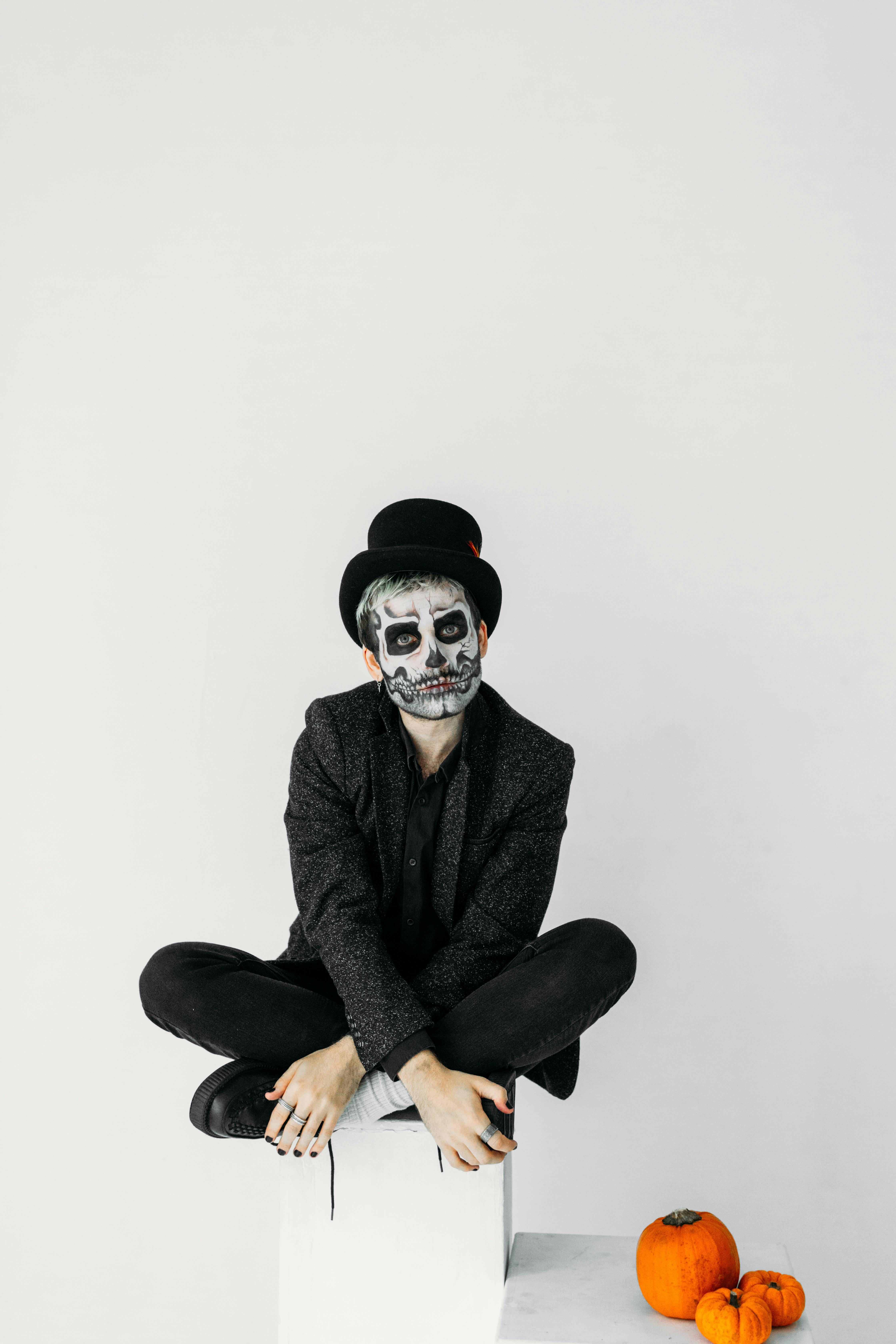 man in black suit with skull face paint