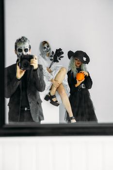 三个穿着怪异万圣节服装的成年人在工作室里摆拍主题照片