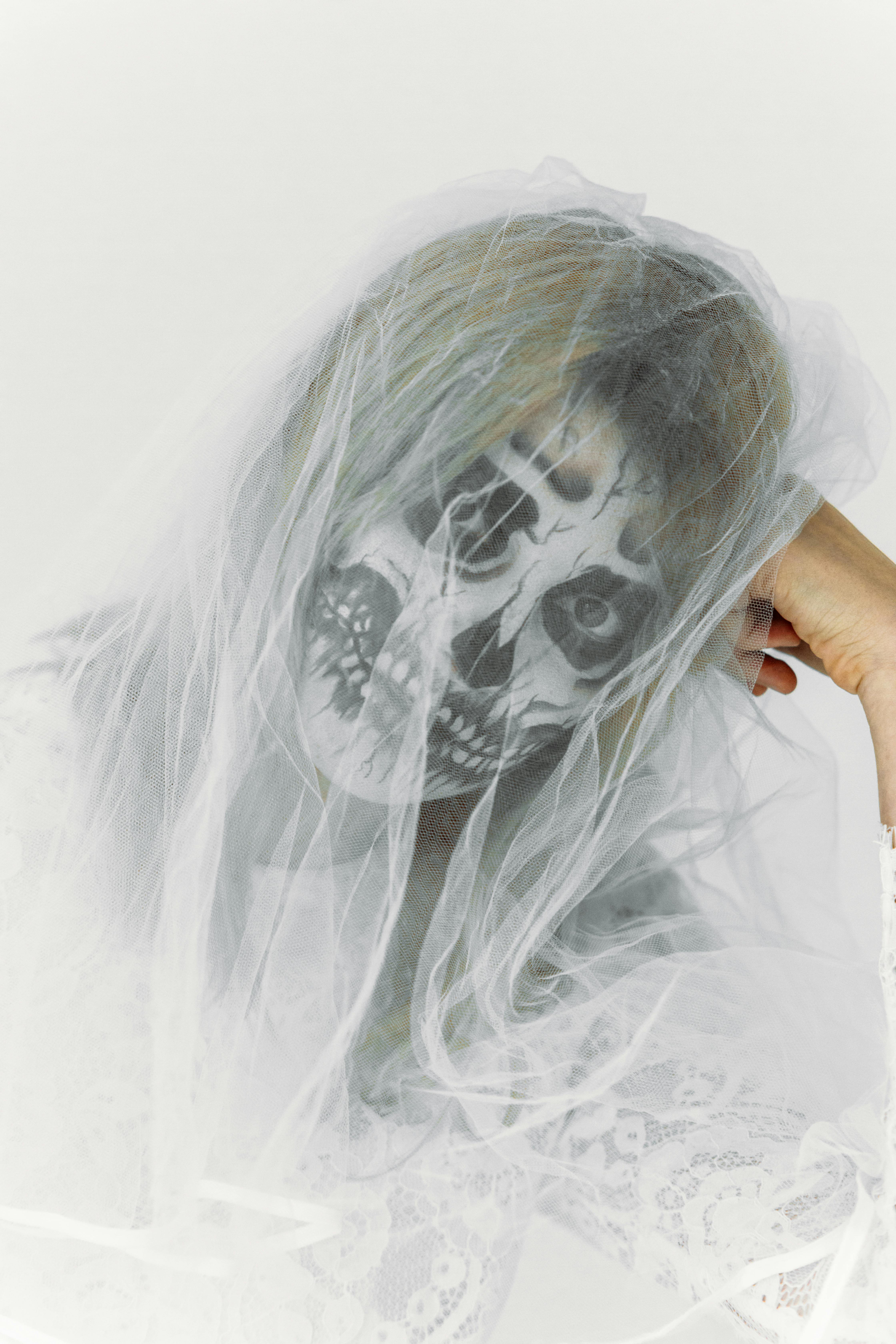 一位女子头戴面纱、面绘骷髅的幻想肖像，唤起了萦绕心头的美感