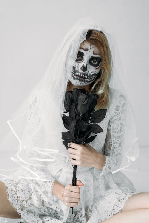Woman in White Lace Wedding Dress With Black Roses