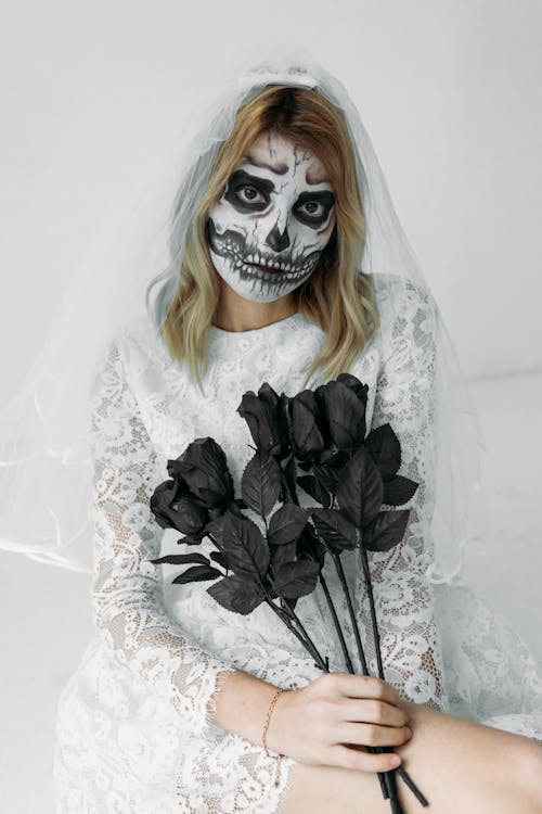 Free Woman in White Floral Lace Dress With Black Roses Stock Photo