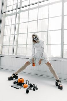 在明亮的工作室里，一位身着哥特式新娘服装的女人摆出了怪异的姿势