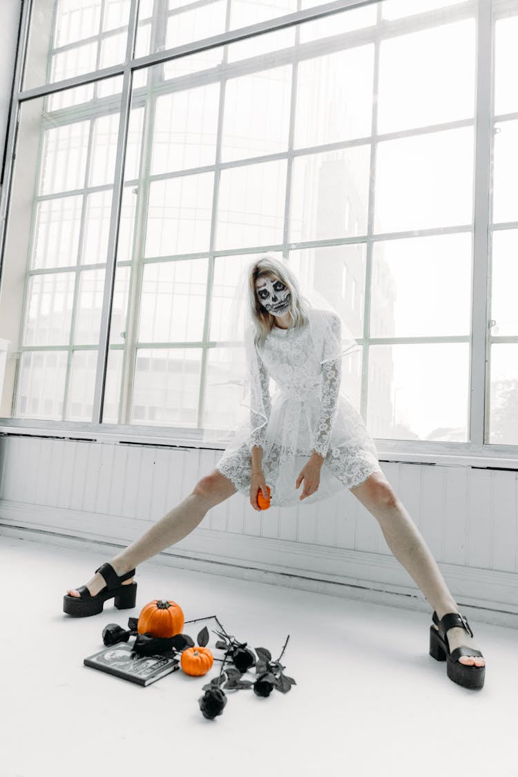 Woman In White Wedding Dress And Holding A Pumpkin