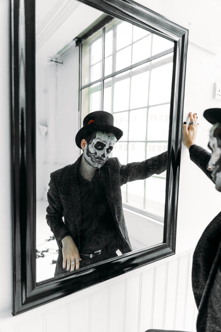 Man In Black Coat Standing Beside A Mirror