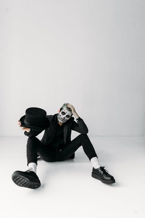 Man in Black Jacket and Black Pants Sitting on Floor