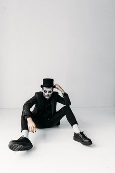 在极简主义工作室拍摄的、头戴高顶帽、妆容为头骨的模特肖像，十分醒目