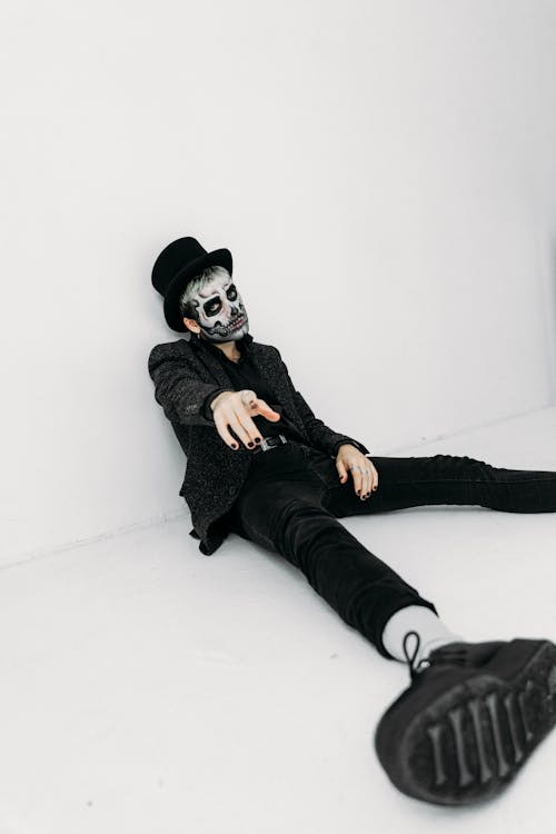 Free Man With Skull Face Paint Sitting On The Floor Stock Photo