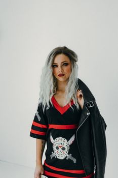 在简约的工作室环境中，时尚的女人与黑色皮夹克合影