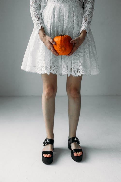 Free Woman in White Dress Holding A Pumpkin Stock Photo