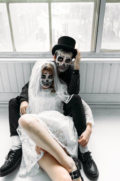 Femme En Robe De Mariée En Dentelle Blanche Et Homme En Costume Noir Avec Des Peintures Pour Le Visage
