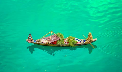 Two Women Riding on a Boat On Green Water