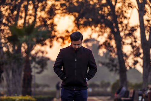 Man Walking in Park at Sunset