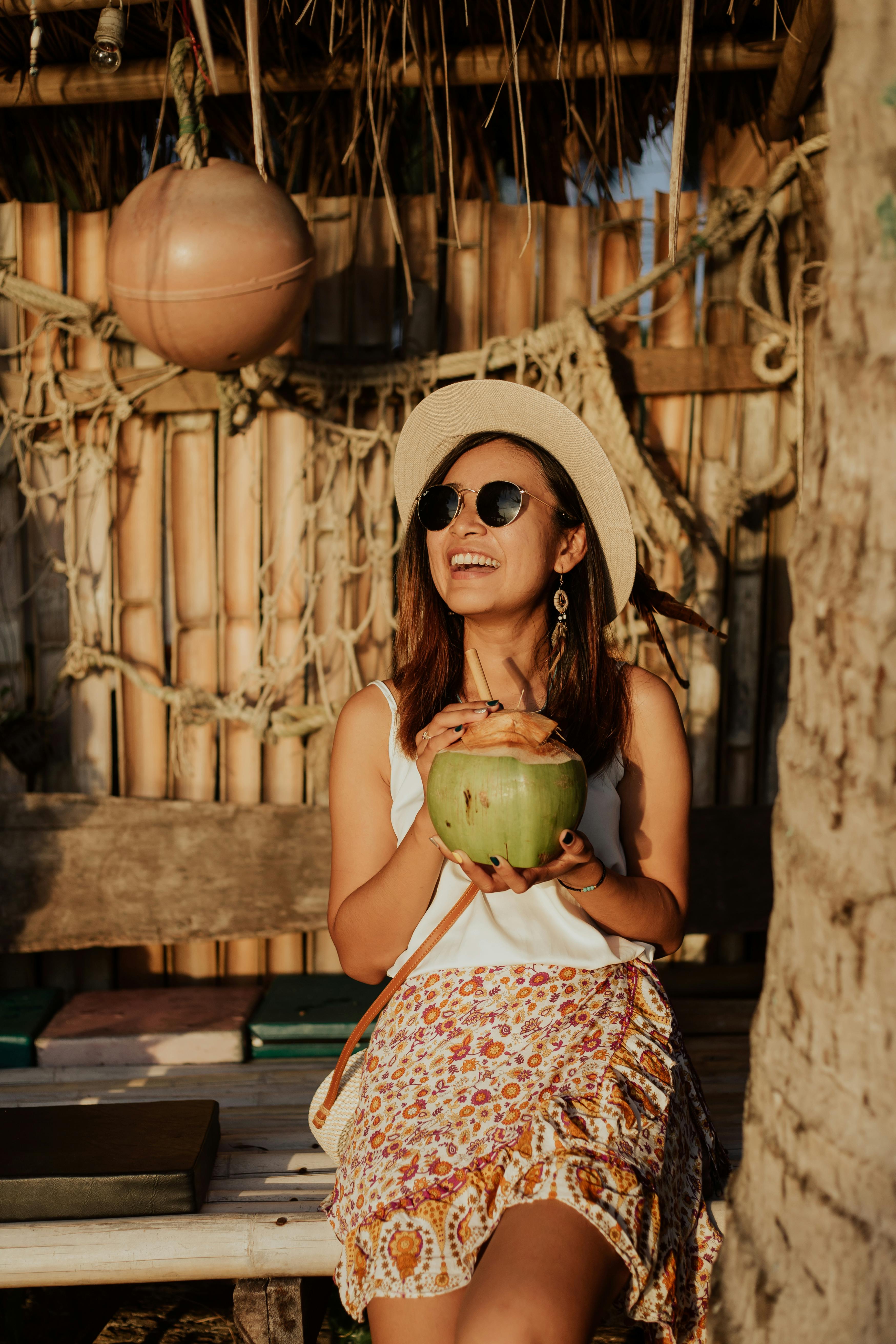 happy woman in vacation drinking a coconut juice