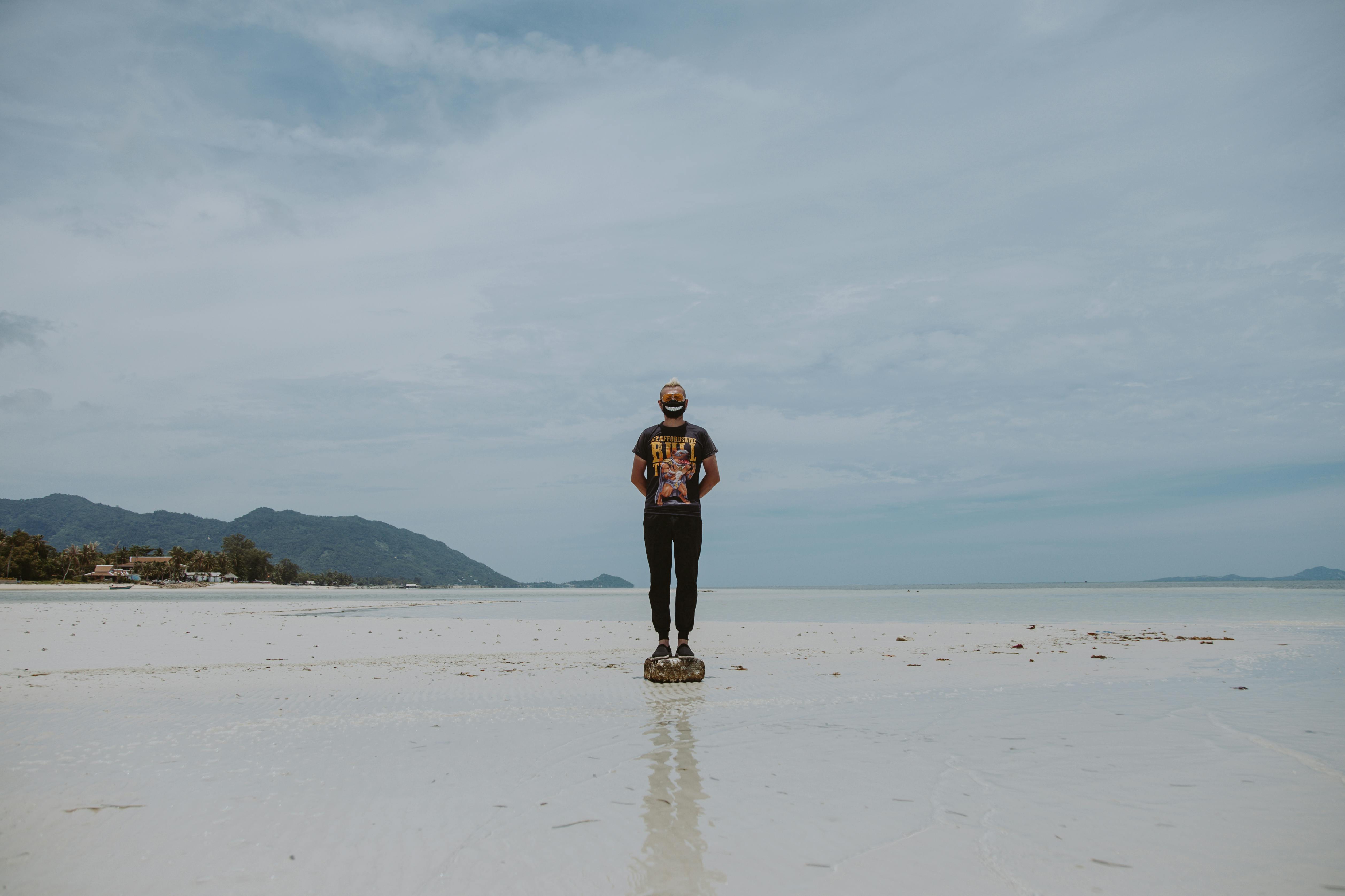 man standing on a rock wearing face mask