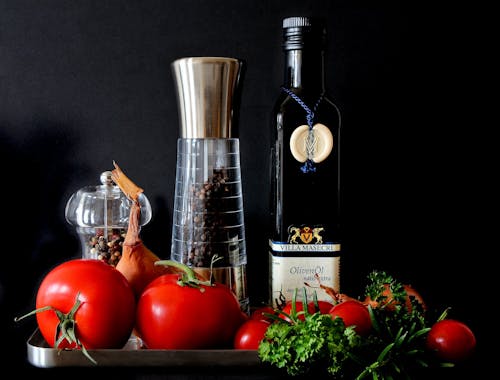 Free Tomatoes Beside Shakers and Olive Oil Bottle Stock Photo