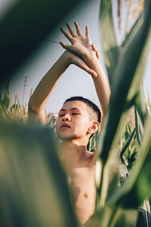 Photo of a Shirtless Man Holding His Arm