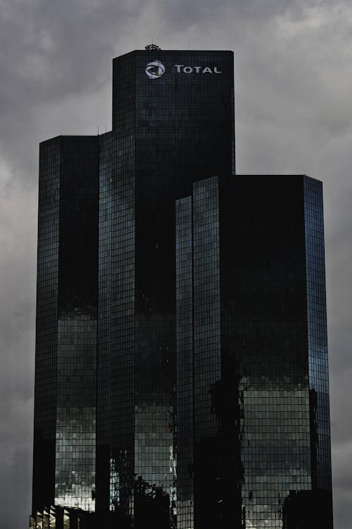 Tall contemporary business offices with modern design with glass mirrored walls located against cloudy sky in city district in street