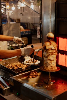Chef prepares doner kebab with fresh ingredients at a food stall.