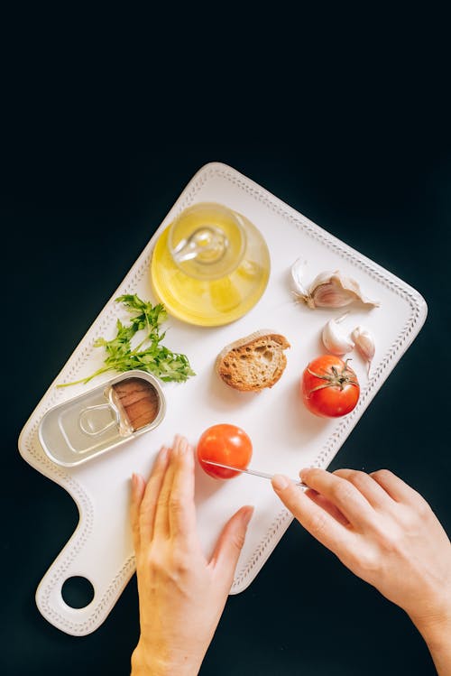 Overhead Shot of a Person's Hands Slicing Tomatoes