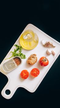 Overhead view of Mediterranean ingredients including tomatoes, garlic, and olive oil.