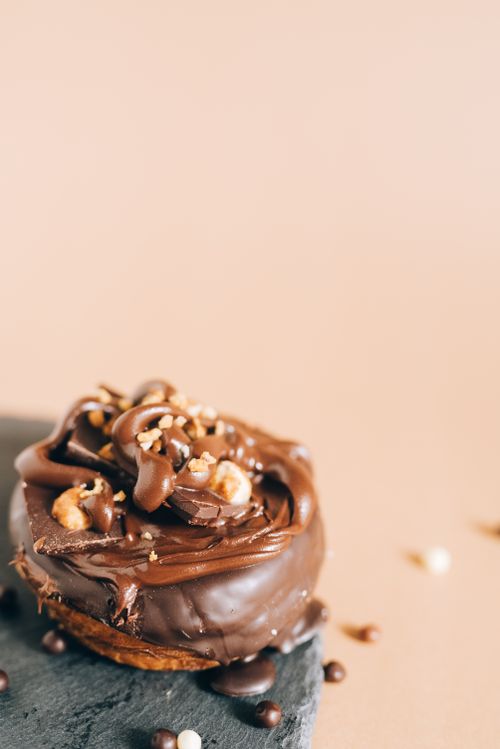 Free A mouth-watering chocolate donut adorned with nuts, perfect for dessert lovers and food photography enthusiasts. Stock Photo