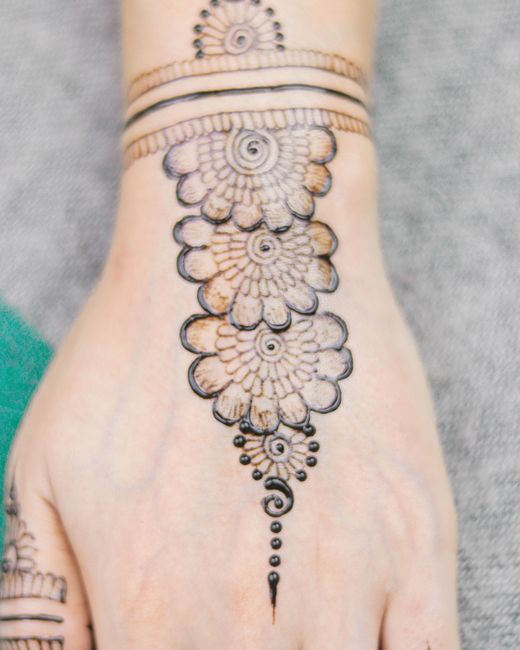 Floral henna design on the back of a hand