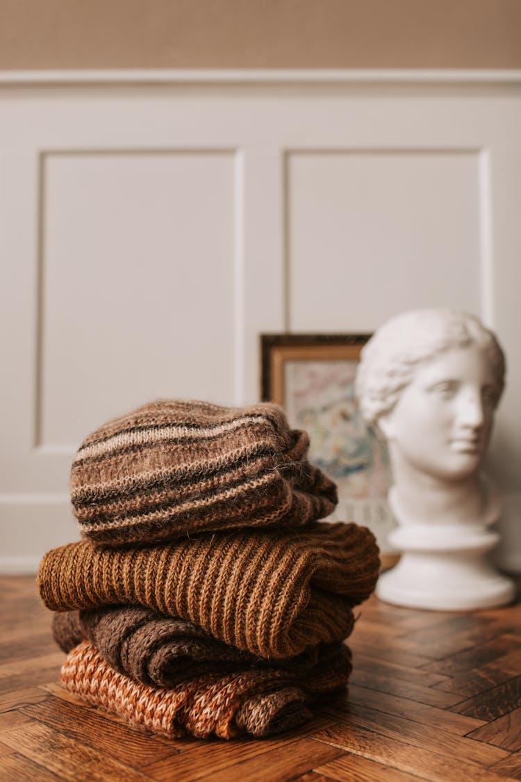 A Brown Knitted Sweaters On Wooden Table