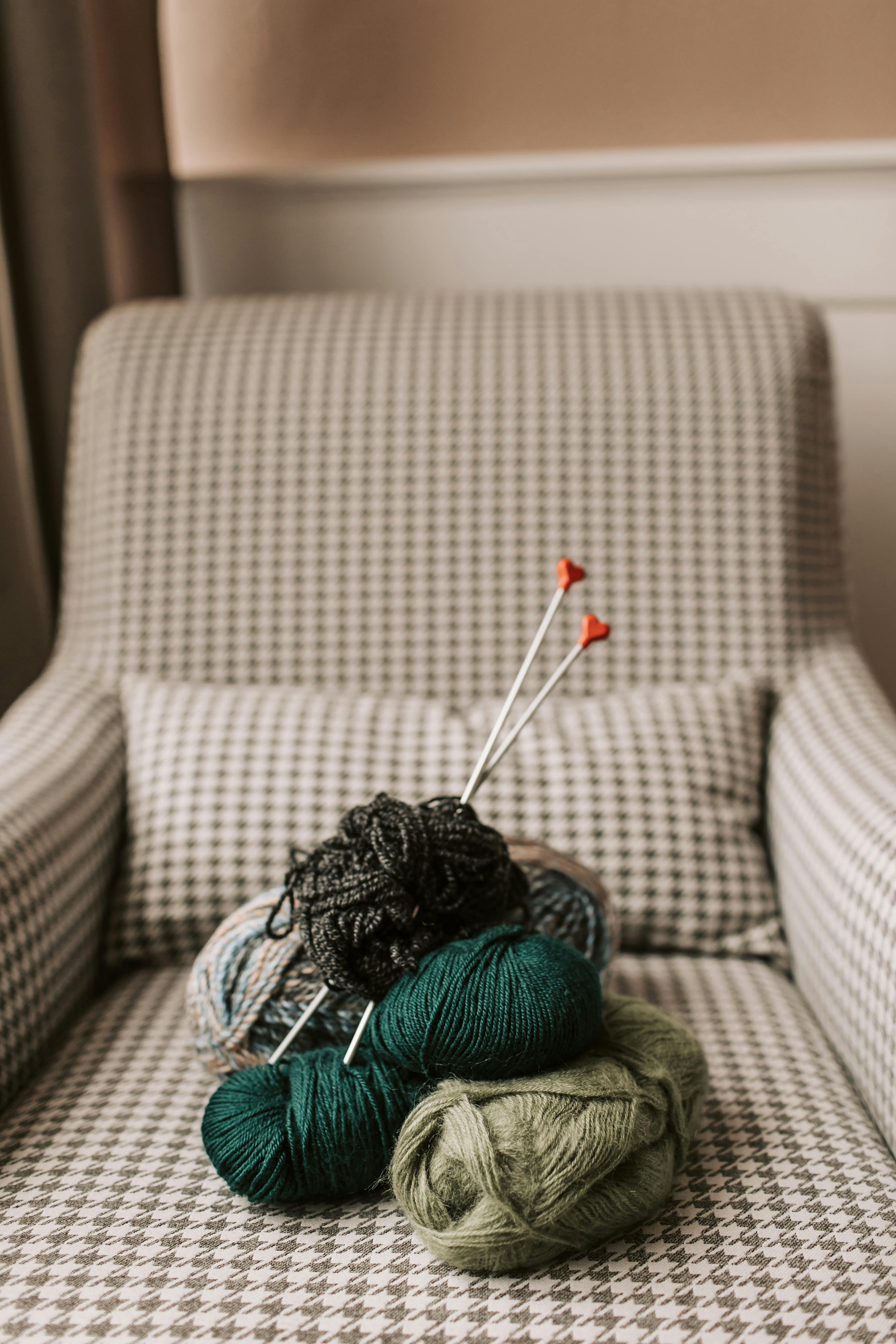 A cozy armchair adorned with colorful yarn and knitting needles, perfect for crafting inspiration.