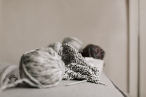 Free A cozy scene featuring knitting needles, yarn, and a handmade project in a minimalist setting. Stock Photo