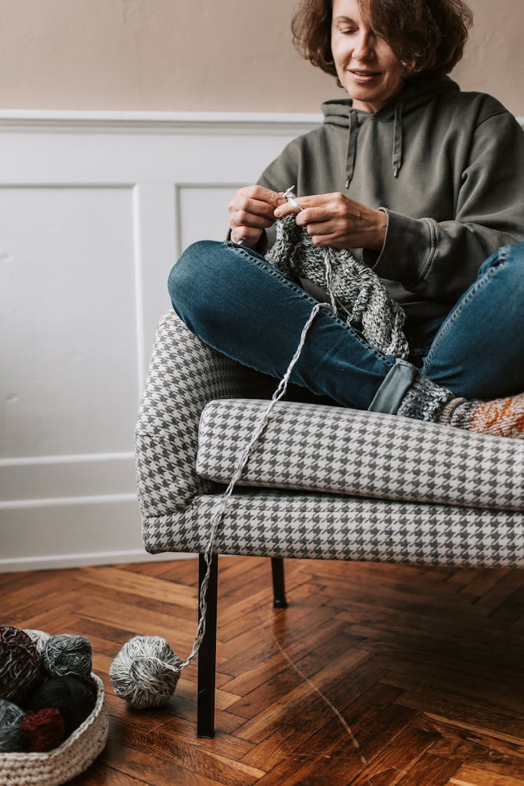 A Woman Knitting Sitting On A Chair