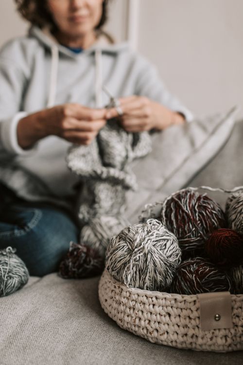 Free Woman knitting with yarn basket, focusing on cozy craft indoors. Stock Photo