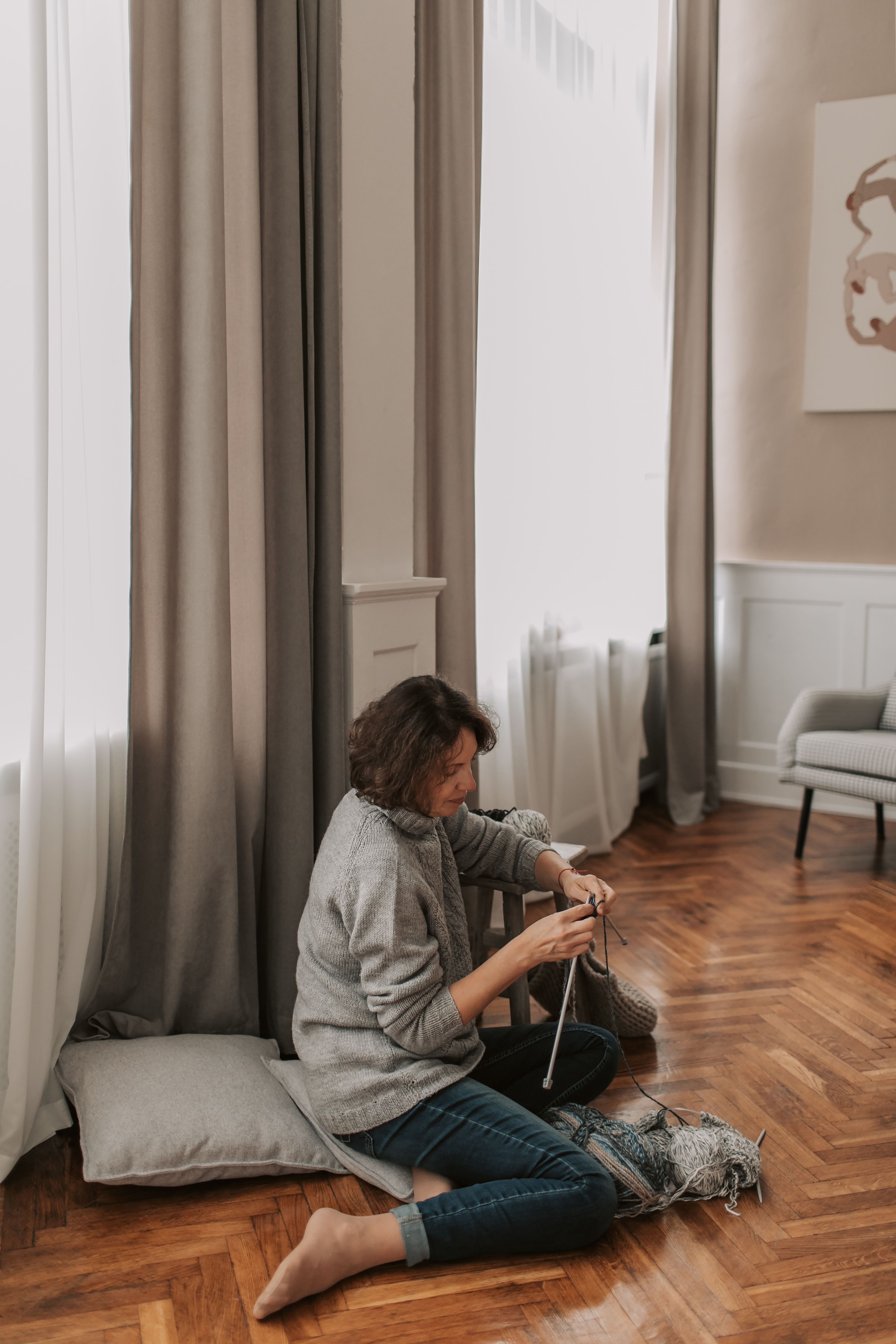 A Woman in Gray Sweater Knitting while Sitting on the Floor · Free ...