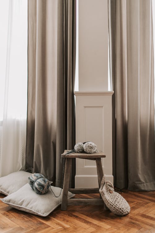 A Yarns on a Wooden Chair Near the Pillows and Knitted Bag on the Floor