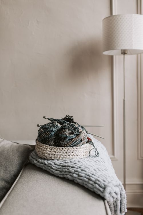 Free Charming living room scene featuring knitting tools and yarn on a sofa, perfect for craft enthusiasts. Stock Photo