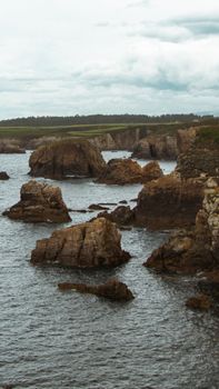 Stunning image of rugged cliffs and dramatic rock formations along a tranquil coastline.