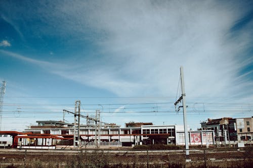 City railroad behind fence under blue sky