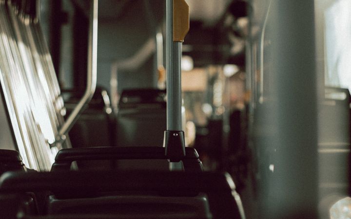 Interior of contemporary public transport with empty passengers seats and metal handles in sunlight