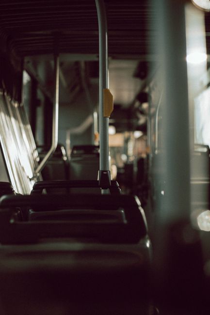 Interior of contemporary public transport with empty passengers seats and metal handles in sunlight