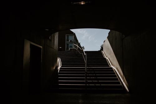 Free Empty tunnel of underground passage in shade and stone stairs with metal railings Stock Photo