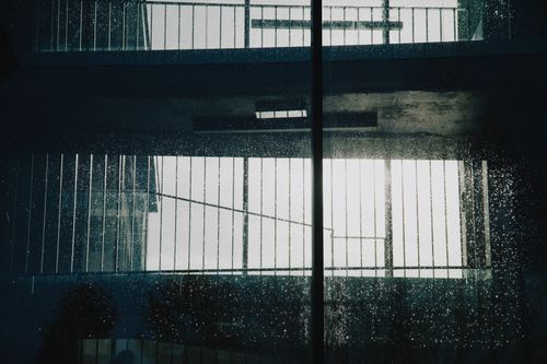 Free Building with reflected stained window and metal bar on dirty glass with fire escape in city on street in daylight Stock Photo