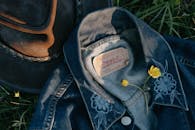 白天，草地上方，牛仔夹克上黄色易碎的小花靠近帽子，从顶视图看去