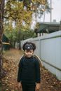 一个穿着戏服的小孩在户外秋叶中行走