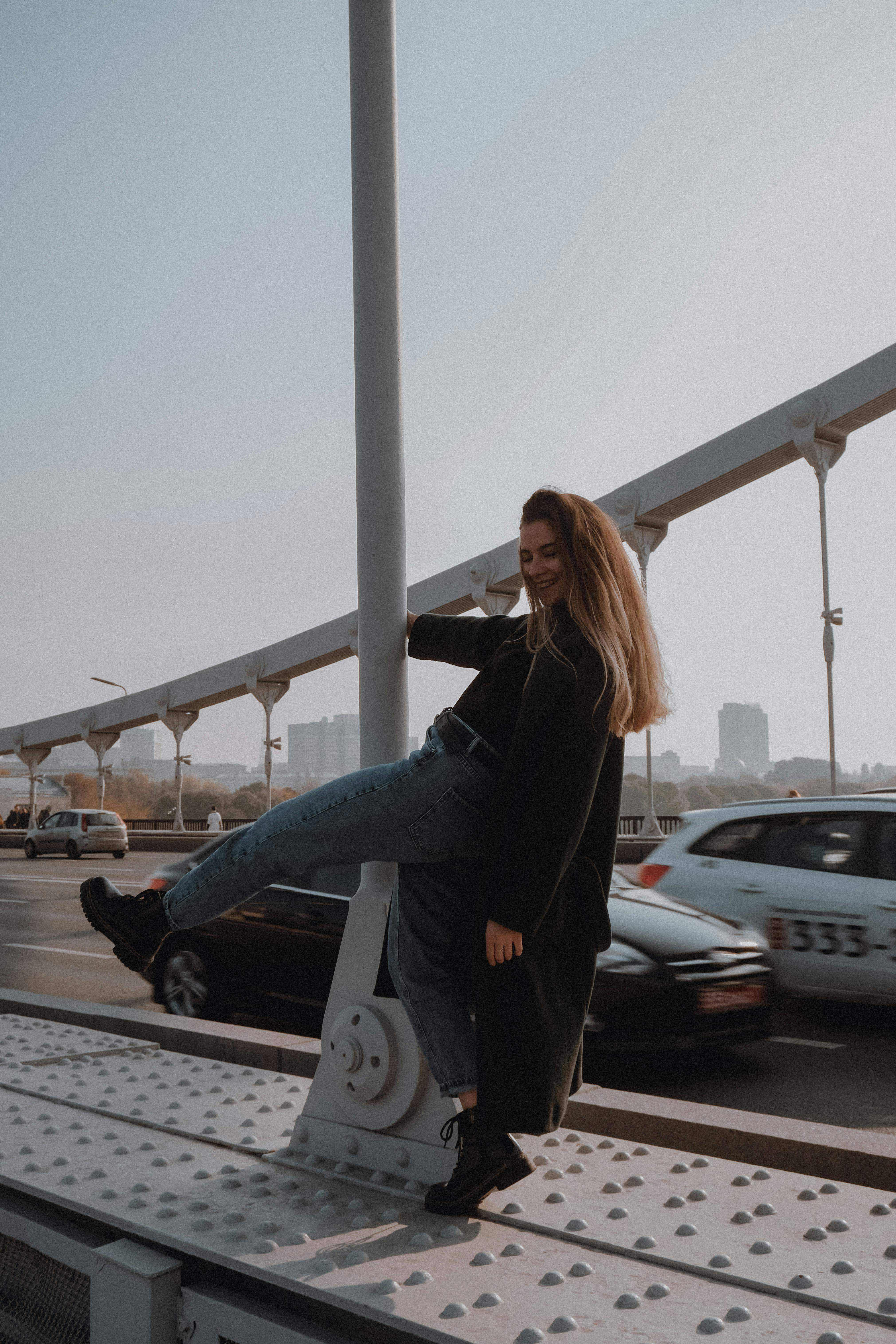 happy trendy woman having fun near urban post and road