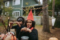 万圣节期间，孩子们穿着戏服，在装饰一新的后院里享用糖果