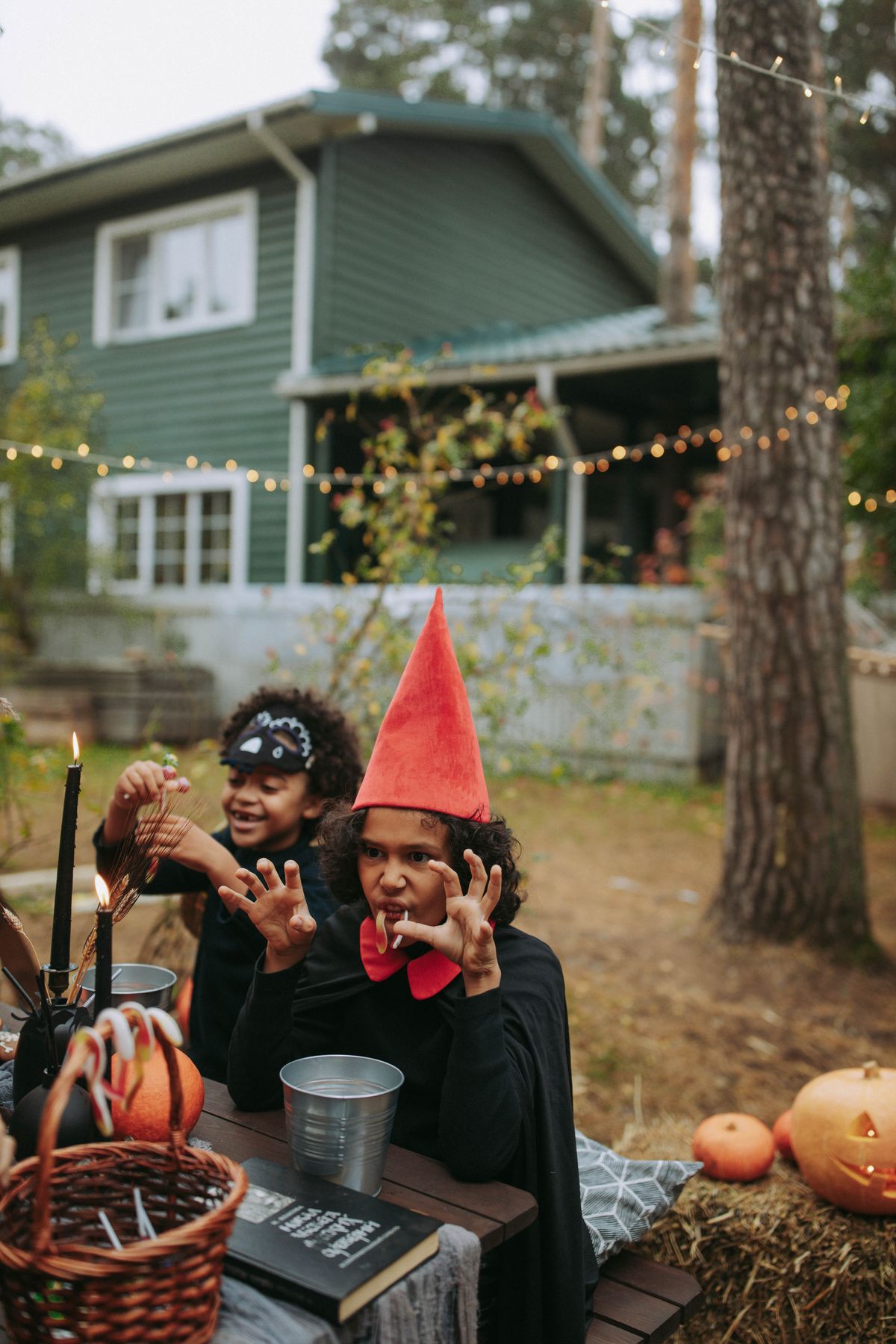 Children in Halloween costumes playing together outdoors.